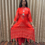 Vermillion red flowy satin silk fabric with high low hemline tasseled edges dotted geometric & floral motifs  Tapered straight pants